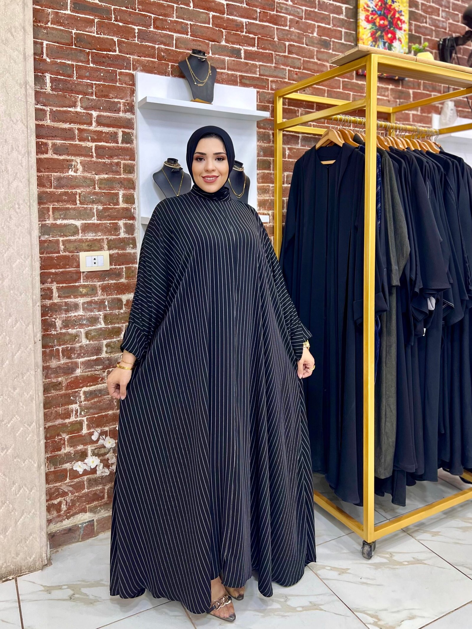 ملحفة اوفر سايز كم قلاب الخامة كتان مستورد ضد الانكماش طري جدا 1 Woman in striped black abaya dress.